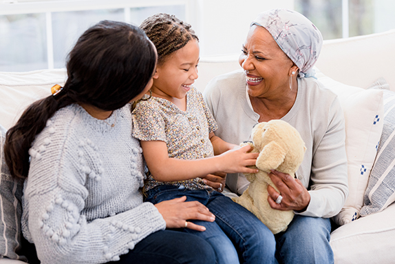 Cancer patient sitting on sofa with family